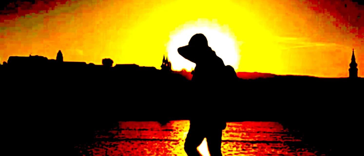 Matt Strout silhouetted against a blazing sunset over the water